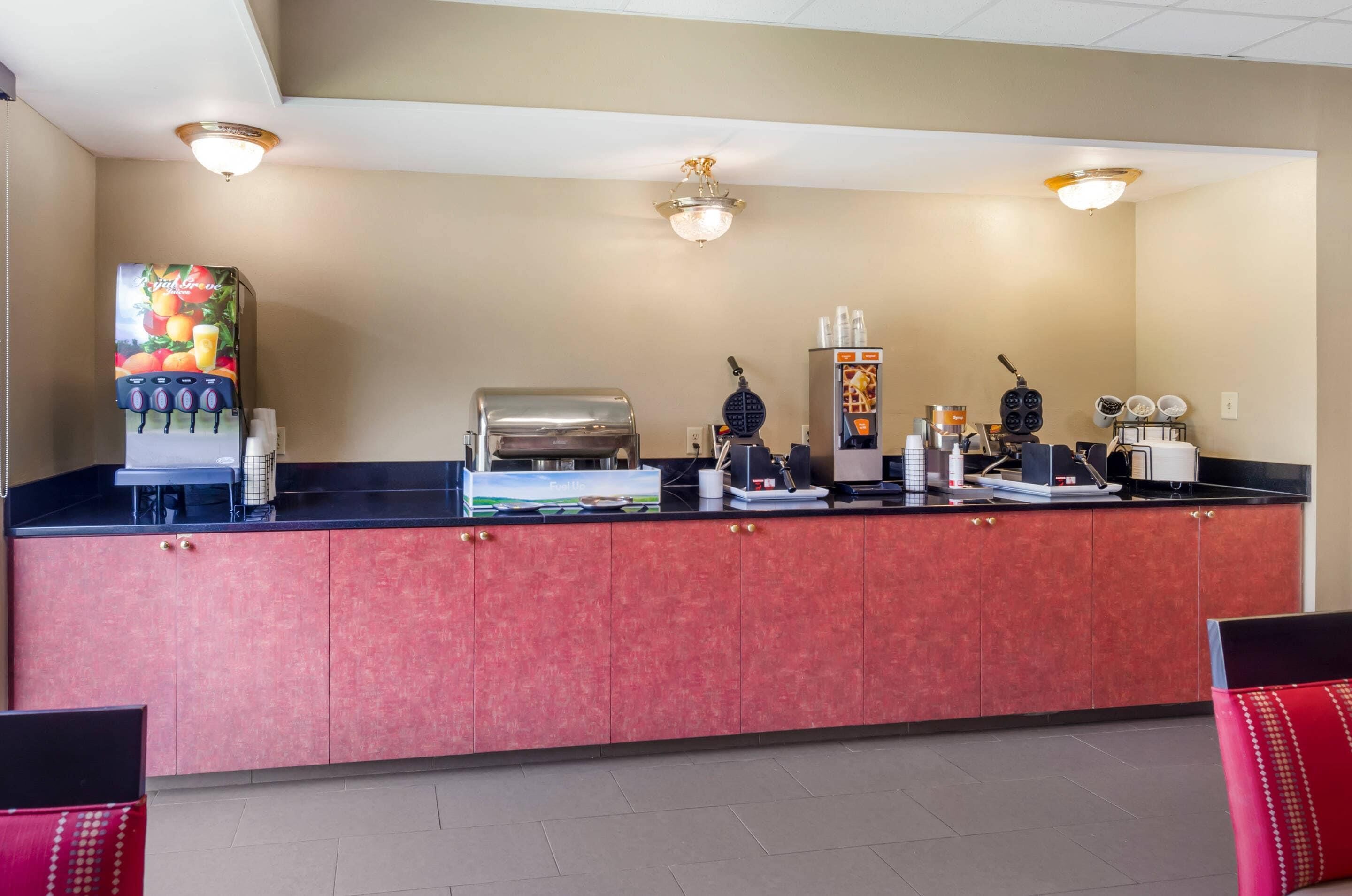 A reception area with a counter, a coffee machine, a waffle maker, and a refrigerator.