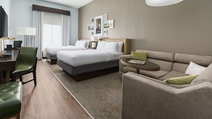 Une chambre d’hôtel avec un lit, un canapé, un bureau et une chaise.