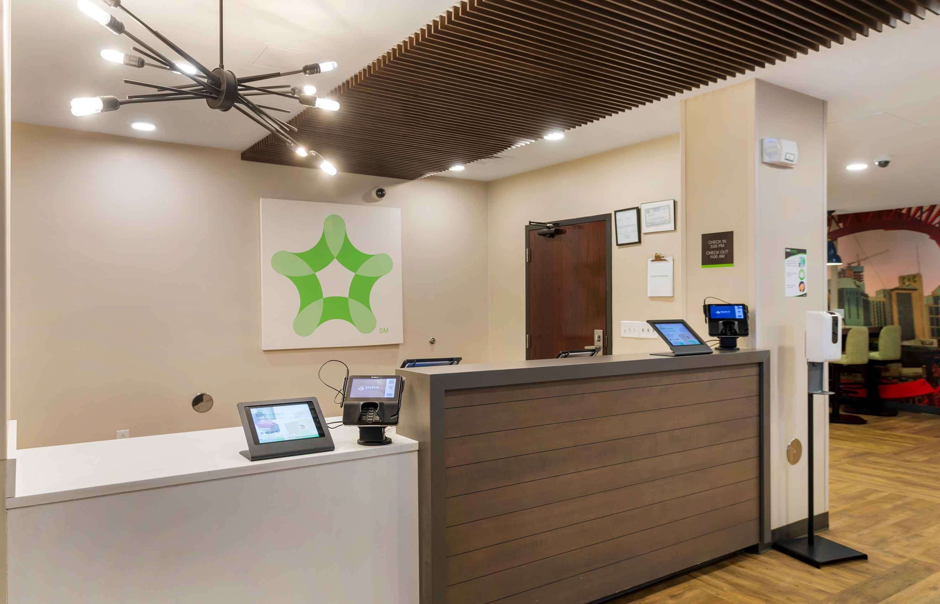 A reception desk with a modern design, a digital display, and a logo on the wall.