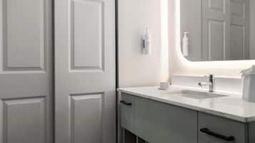 Une salle de bain avec un lavabo blanc, un miroir et un porte-serviettes.
