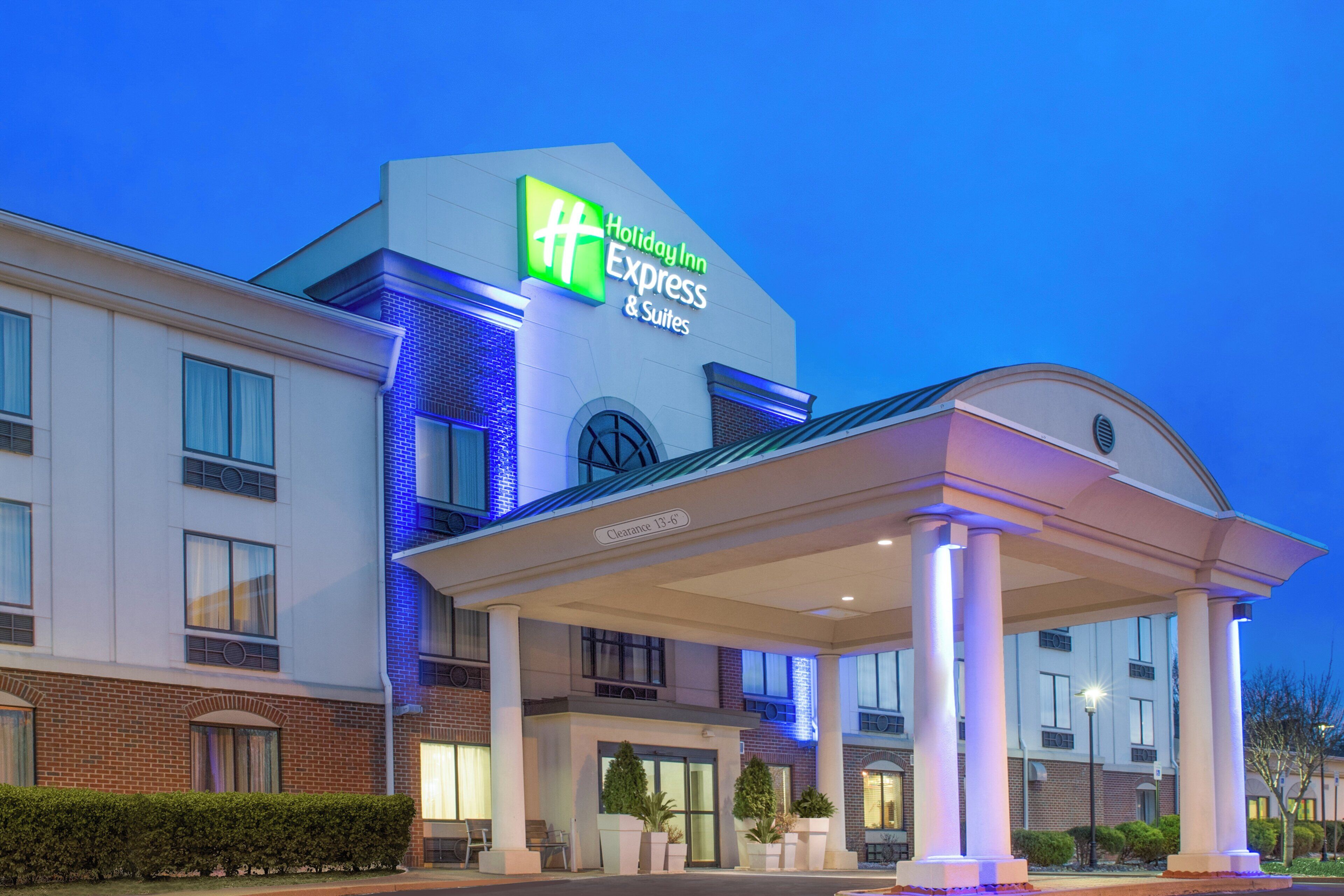 Un hotel Holiday Inn Express & Suites con entrada cubierta y cielo despejado.