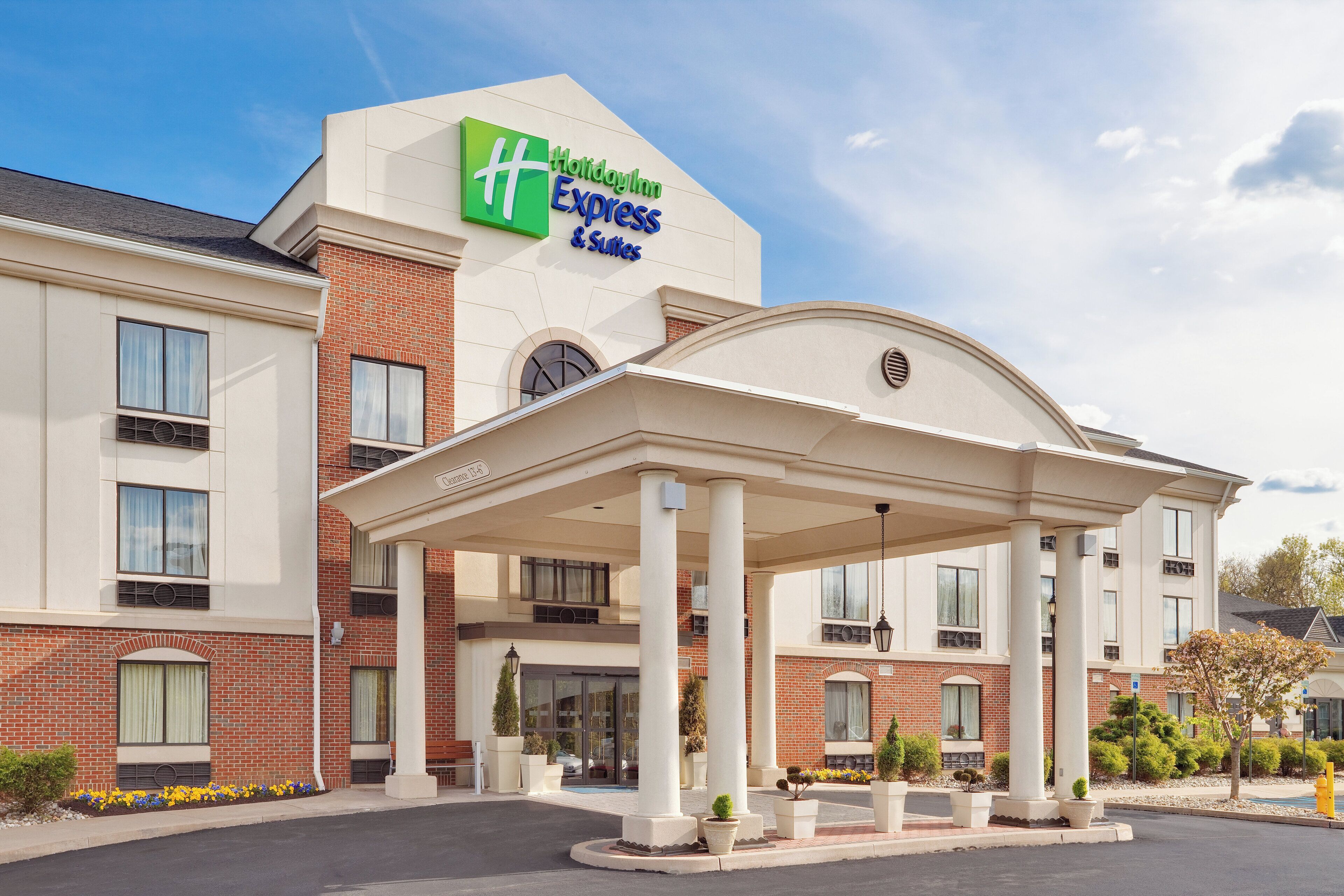Un bâtiment de l’hôtel Holiday Inn Express & Suites, doté d’une entrée abritée et d’une façade en briques.