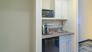A compact kitchen with a microwave, coffee maker, and dishwasher.