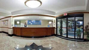 A hotel reception area with a marble floor, a reception desk, and a glass door leading to the lobby. - Holiday Inn Express Hotel & Suites Easton by IHG (Easton)
