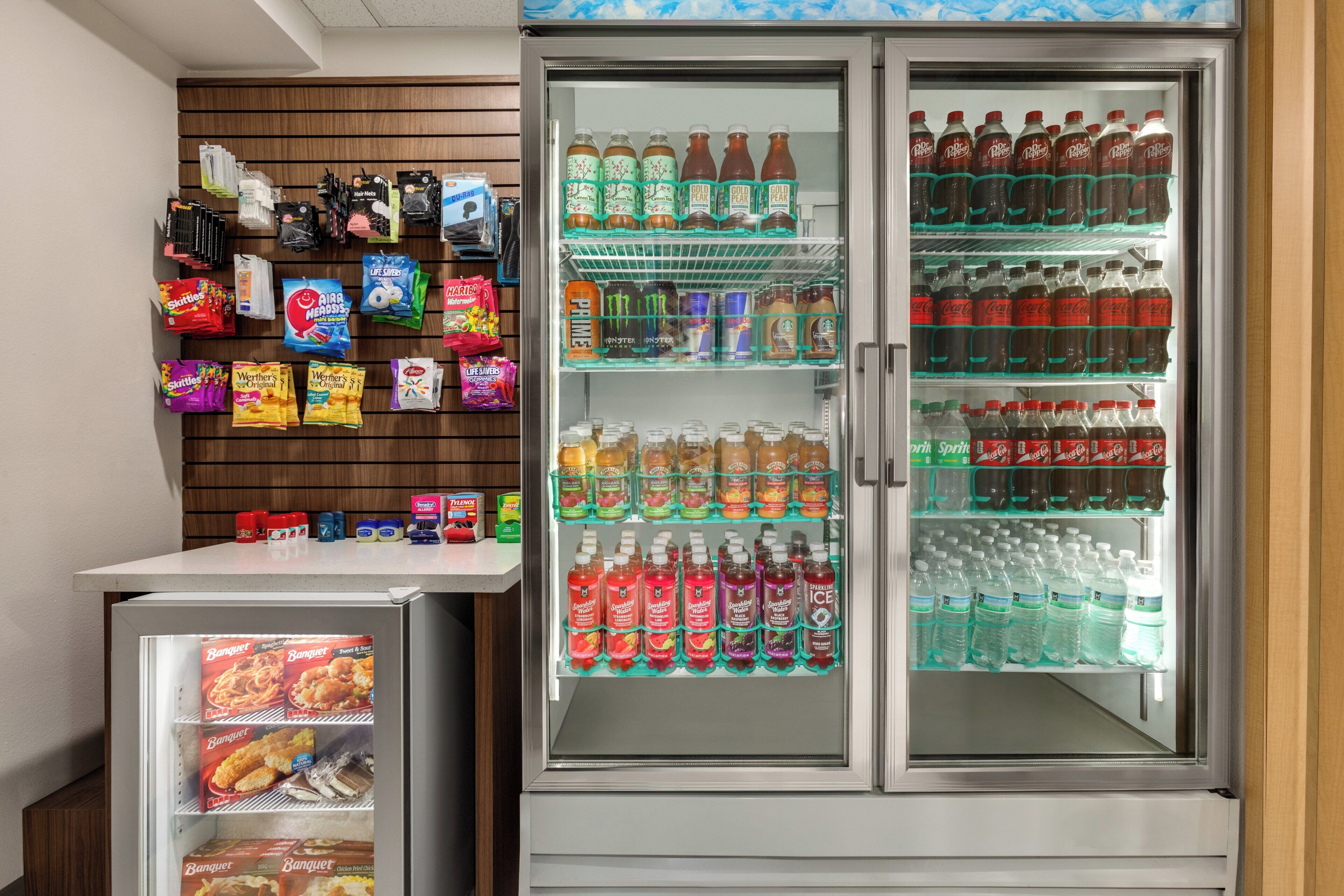 Ein Getränkeautomat mit Snacks und Getränken, darunter eine Kühltheke mit verschiedenen Erfrischungsgetränken.