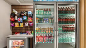 En automattankstation med snacks och drycker, inklusive ett kylt utrymme med olika sorters drycker.