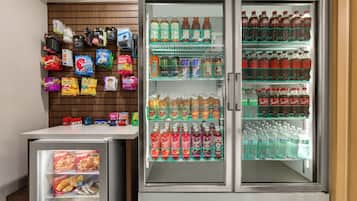 Ein Getränkeautomat mit Snacks und Getränken, darunter eine Kühltheke mit verschiedenen Erfrischungsgetränken.