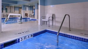 En inomhuspool med en djupmarkering som visar 1,07 meter, en hoppställning och en stol placerad nära poolkanten.