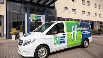 Ein weißer und grüner Lieferwagen vom Holiday Inn Express vor dem Hotel geparkt.