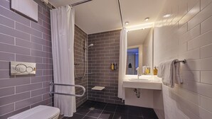 A modern bathroom with a shower, toilet, and sink. - Holiday Inn Express Frankfurt Airport by IHG (Moerfelden-Walldorf)