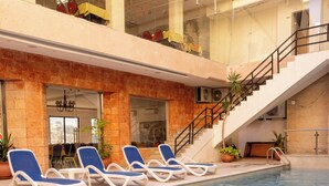 A swimming pool with lounge chairs and a staircase leading to an upper level. - Petra Palace Hotel (Wadi Musa)
