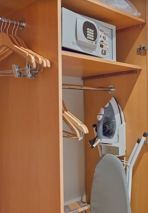 Een compacte badkamer met een douche, toilet en een klein kastje met een haardroger.