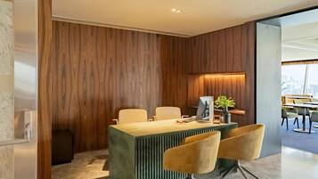A modern office space with a wooden accent wall, a central desk with two chairs, and a computer setup.