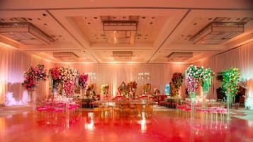 Une vaste salle dotée d’un plancher ciré, de gradins et de compositions florales.