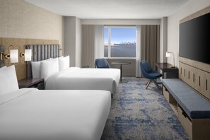 A hotel room with two beds, a desk, a chair, a TV, and a view of the city skyline. - Hyatt Regency Jersey City on the Hudson (Jersey City)