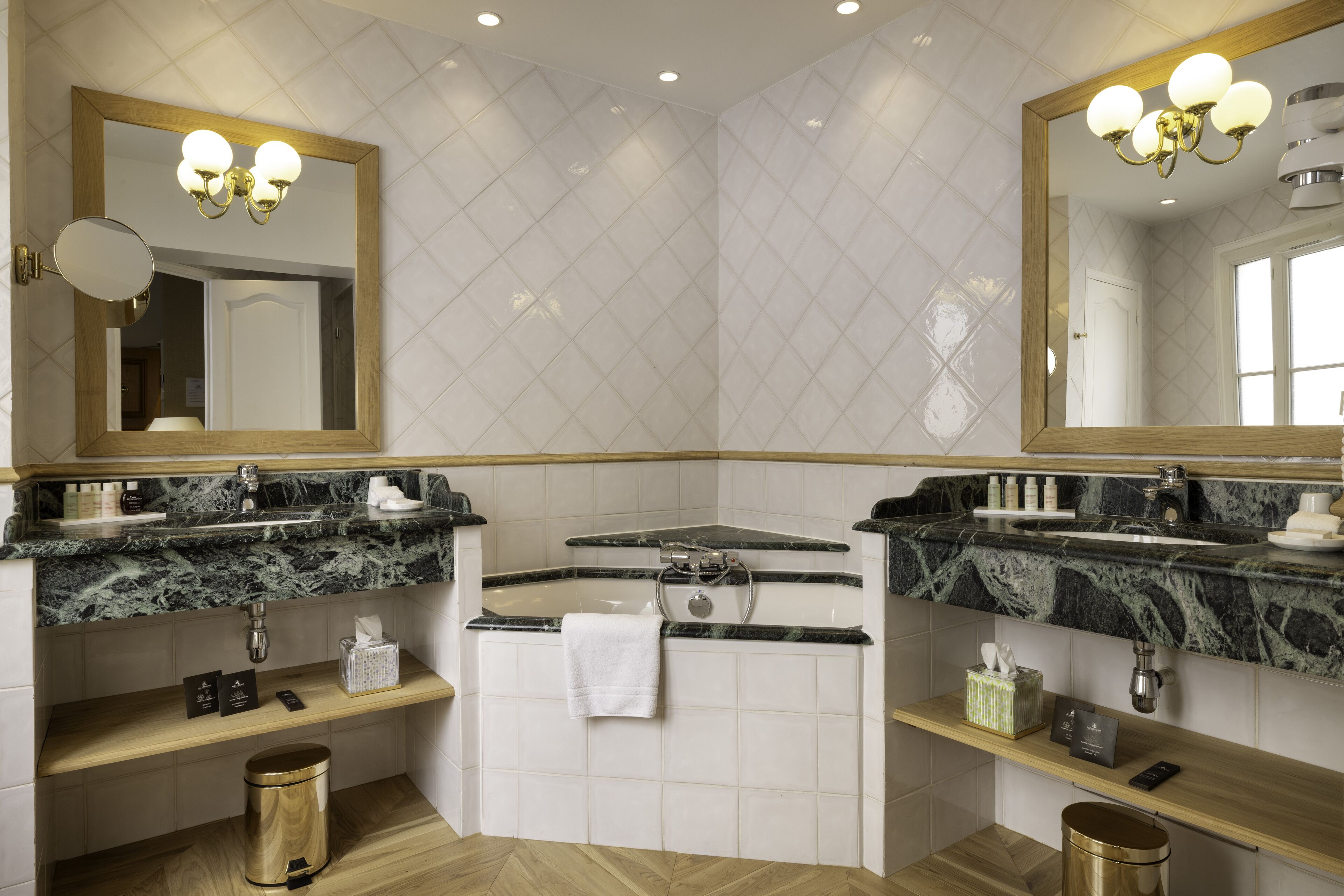 Un baño moderno con dos lavamanos, un espejo grande y un tocador con artículos de aseo.
