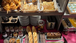 Una variedad de productos horneados, como pasteles y pan, dispuestos en bandejas.