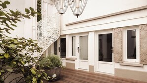 A modern building with a wooden deck, white walls, and decorative screens. - Hôtel Eiffel Segur (Paris)