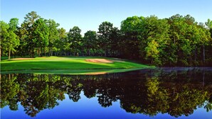 A golf course with a pond reflecting the trees and sky. - The Tides Inn (Irvington)