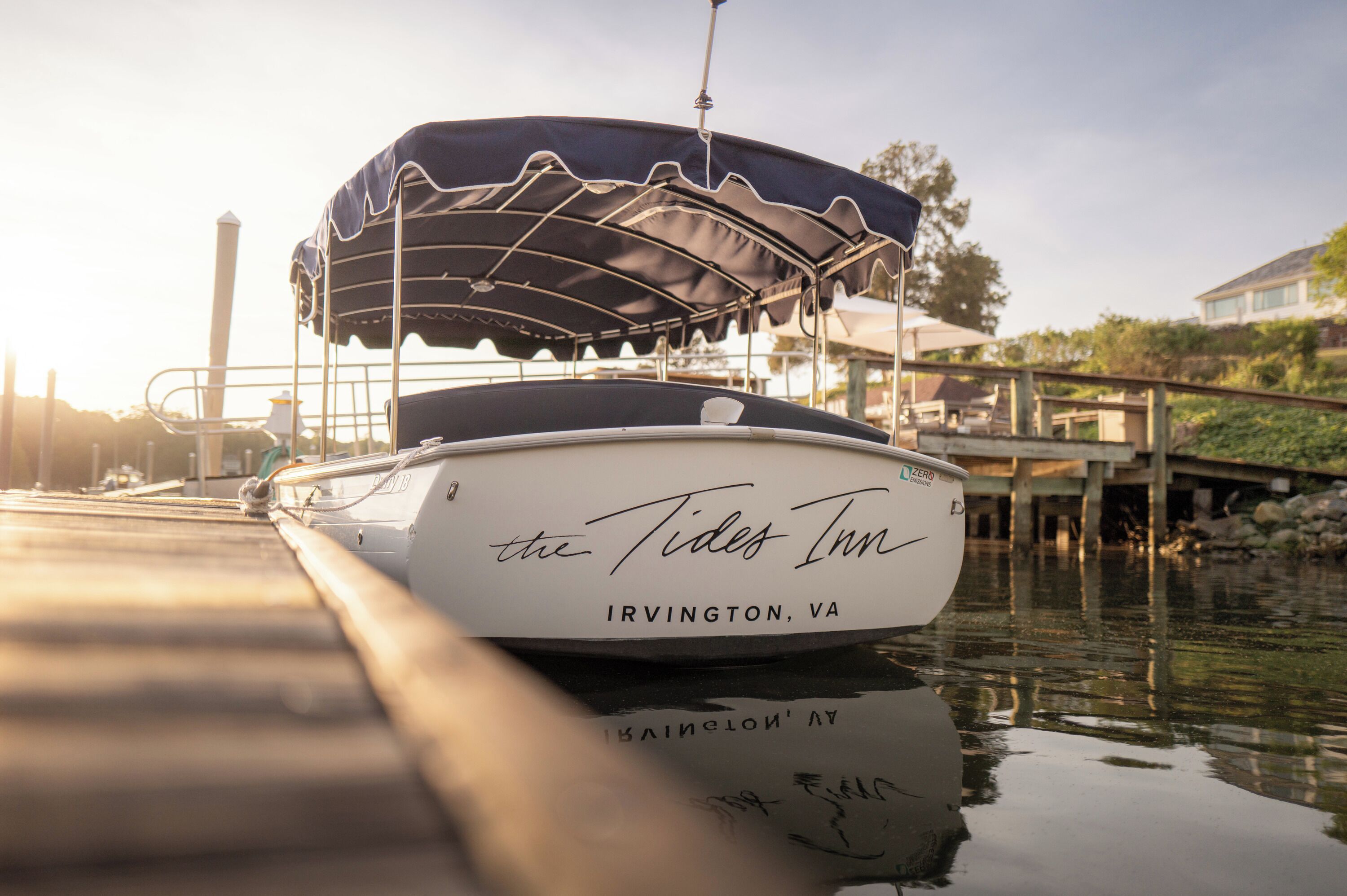 A boat named 'the Tide Inn' docked at a pier with a covered area.