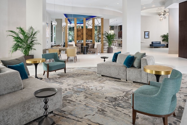 Un hall espacioso con diseño moderno, que incluye sofás, sillones y una mesa de centro.