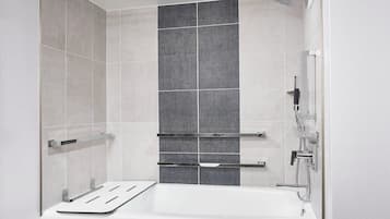 Ein modernes Badezimmer mit Badewanne, Dusche und Handtuchhaltern.