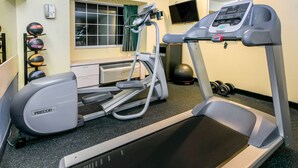 A gym with a treadmill, elliptical, and weights. - Days Inn & Suites by Wyndham Pryor (Pryor)