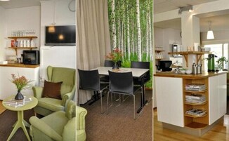 Uma sala de estar moderna com um sofá verde, uma mesa redonda pequena e uma televisão na parede.