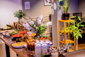 A buffet table with various food items and a floral centerpiece.