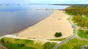 A beach with a sandy shore, a walking path, and a small boat dock. - Break Sokos Hotel Eden (Oulu)