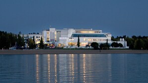 A modern building with a glass facade, situated by a body of water. - Break Sokos Hotel Eden (Oulu)
