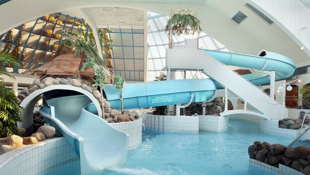 An indoor water park with slides, a pool, and a rock formation. - Break Sokos Hotel Eden (Oulu)