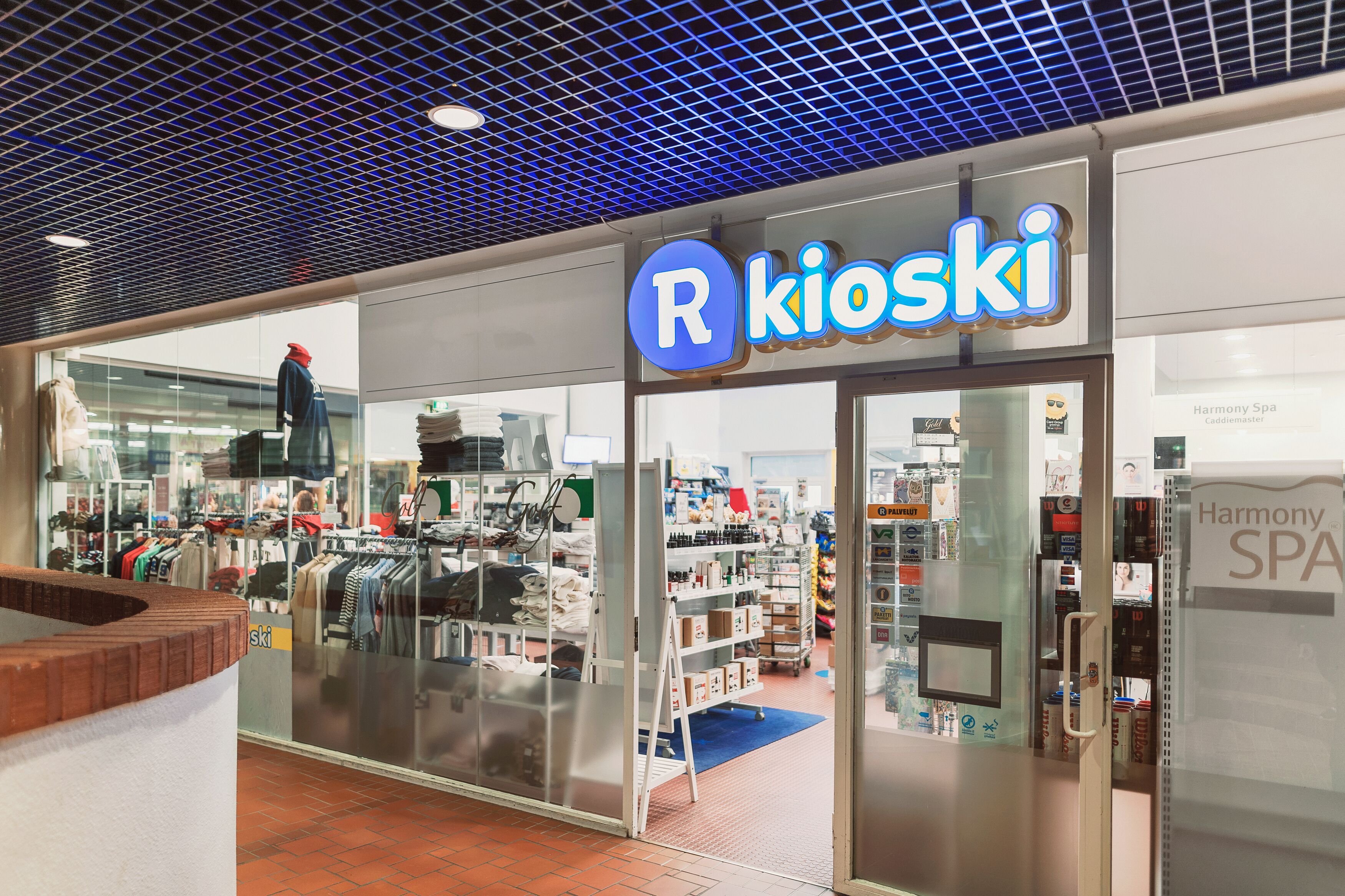 A store named R Kioski with a variety of clothing and accessories on display.