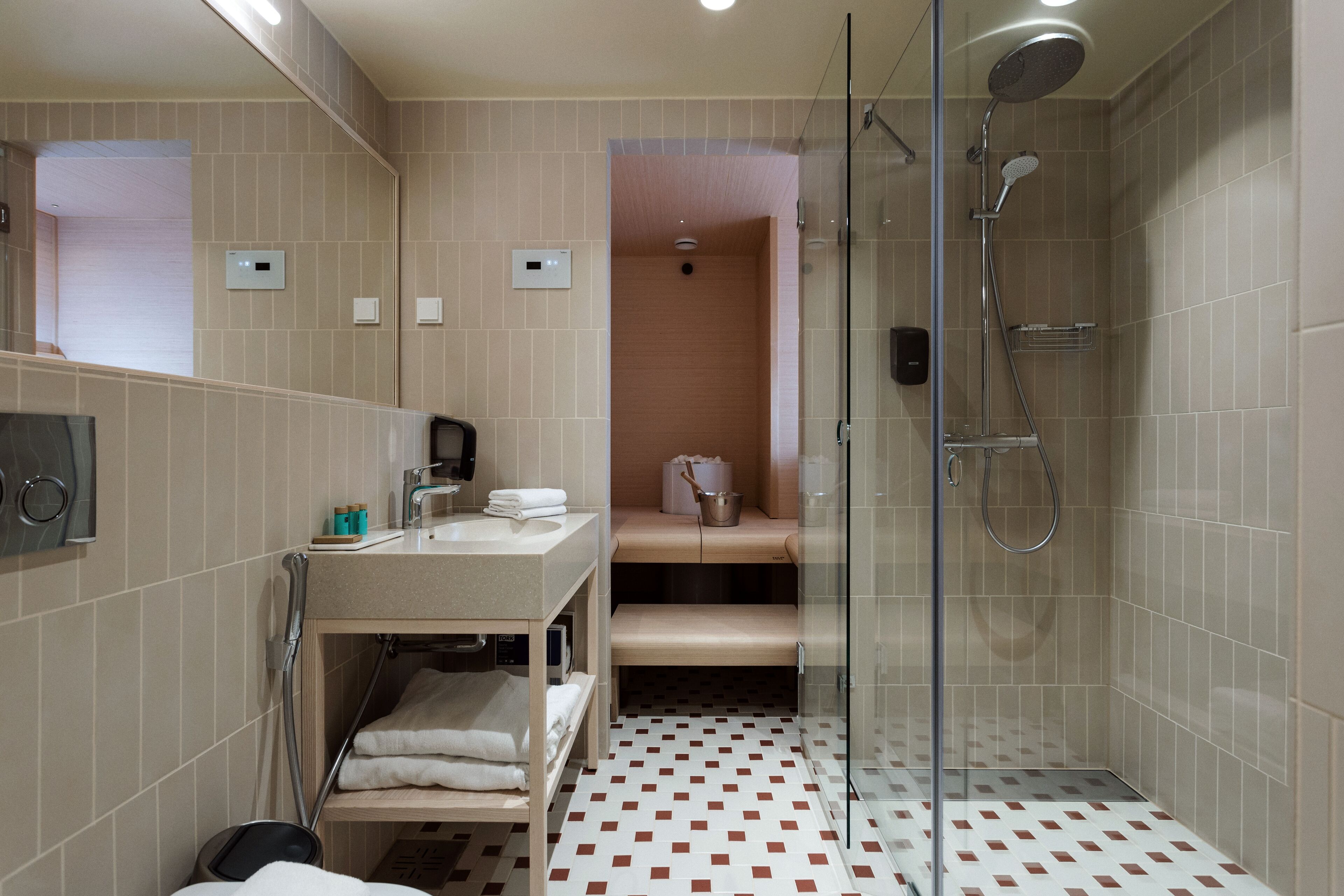 Une salle de bain moderne avec une douche à parois de verre, un meuble-lavabo avec un évier et un miroir, et des toilettes.