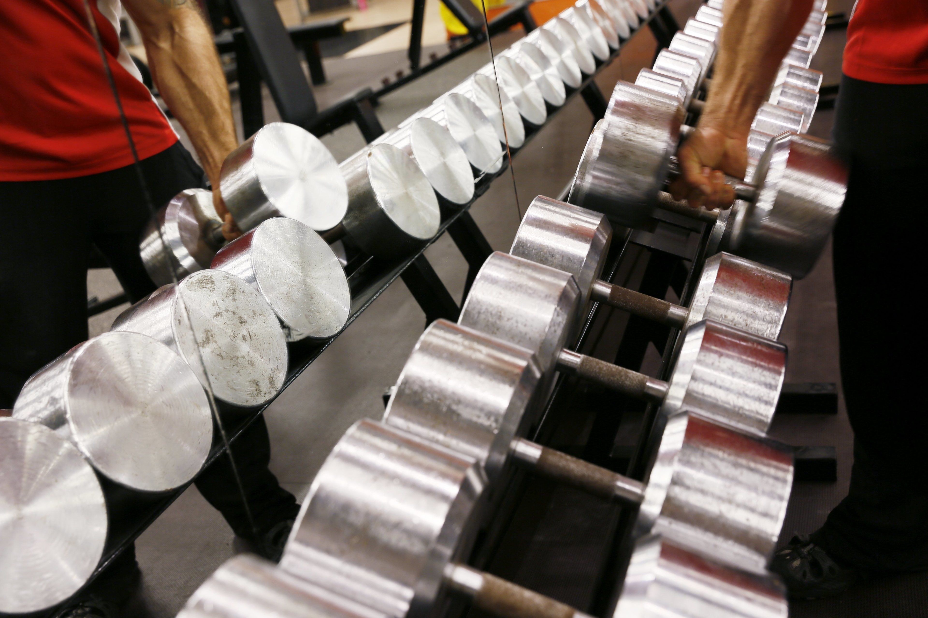 Et transportbånd med cylindriske metalgenstande, sandsynligvis en del af en produktionsproces.