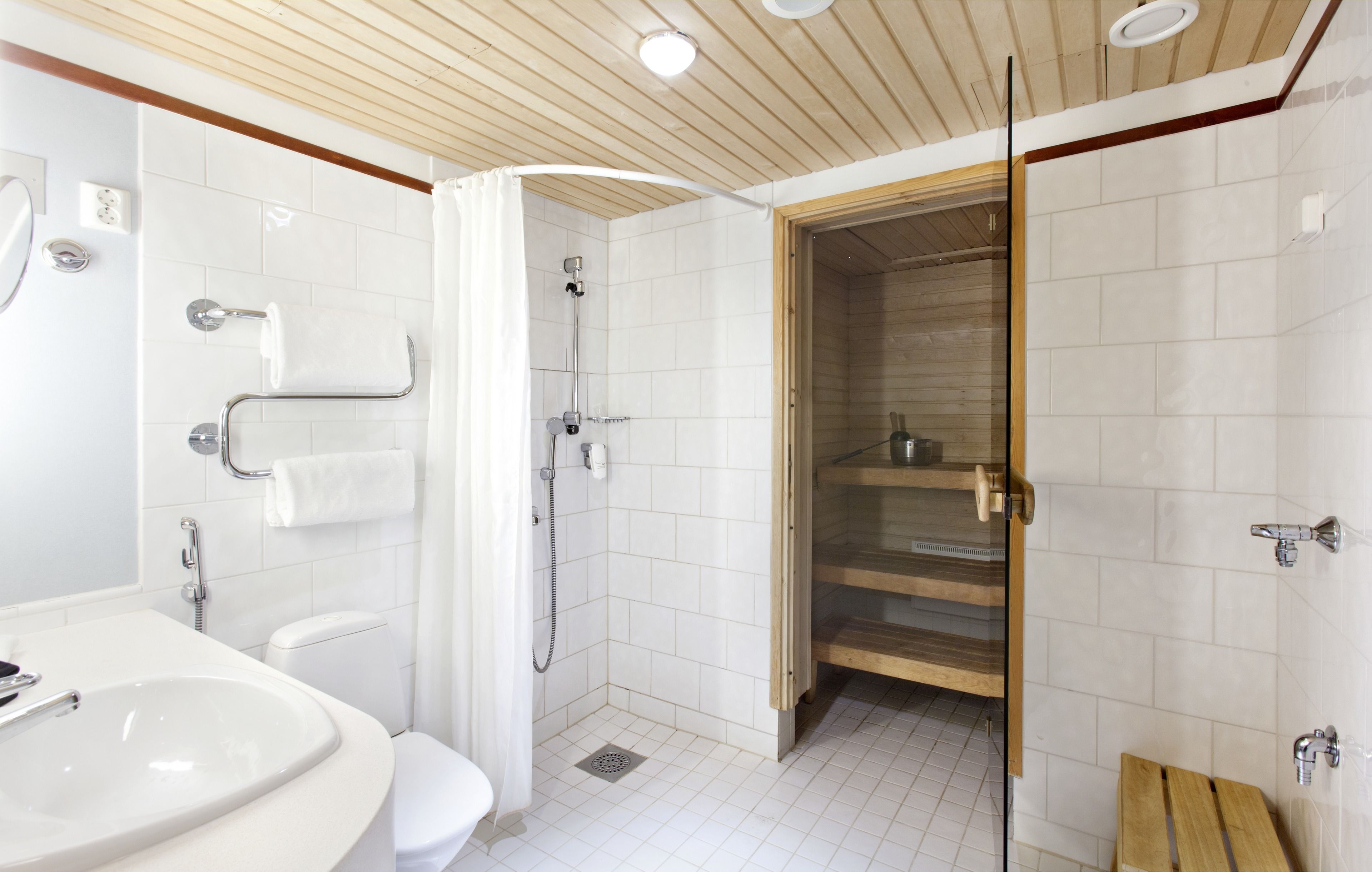 A modern bathroom with a shower, toilet, and sink.