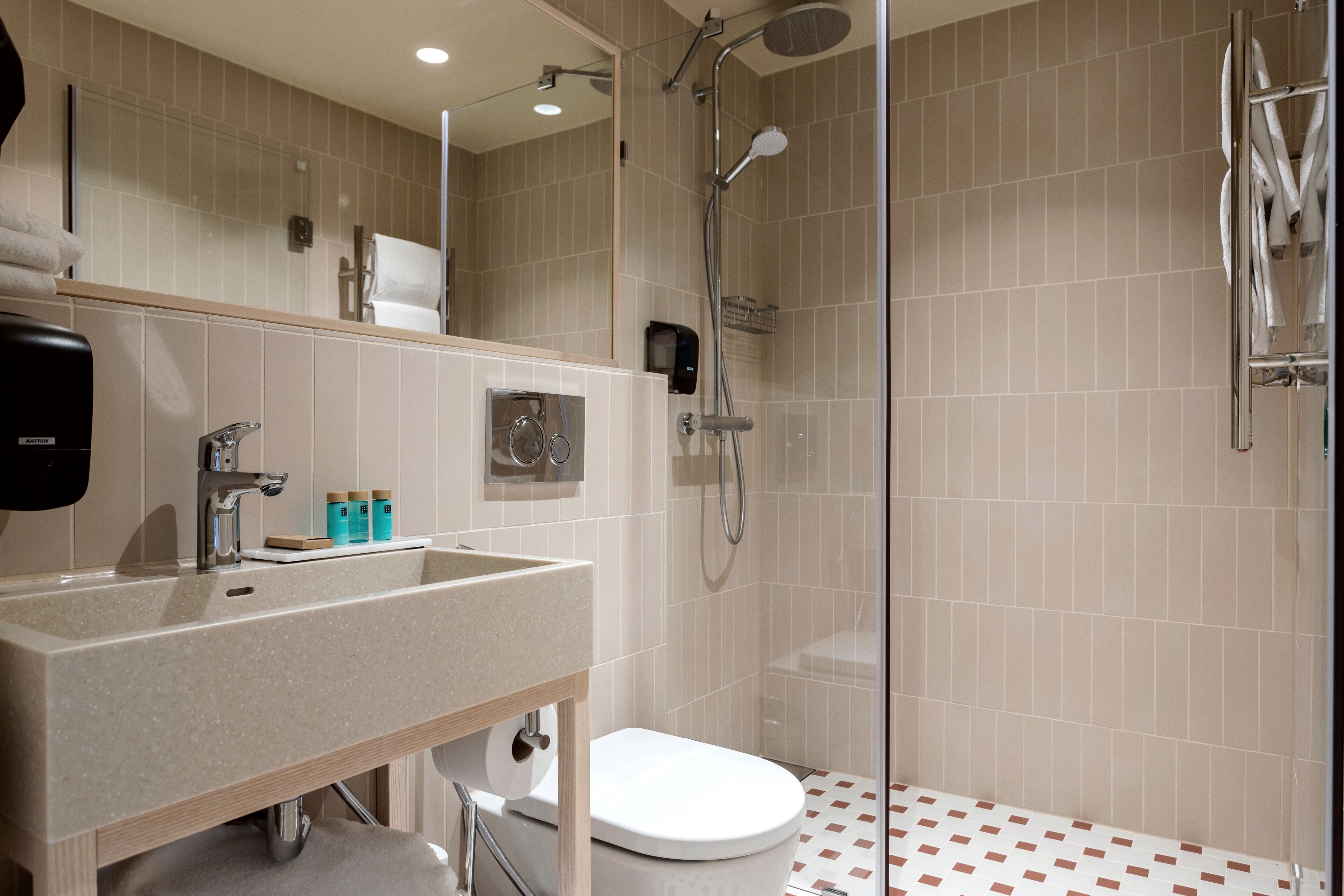A modern bathroom with a sink, toilet, and shower.