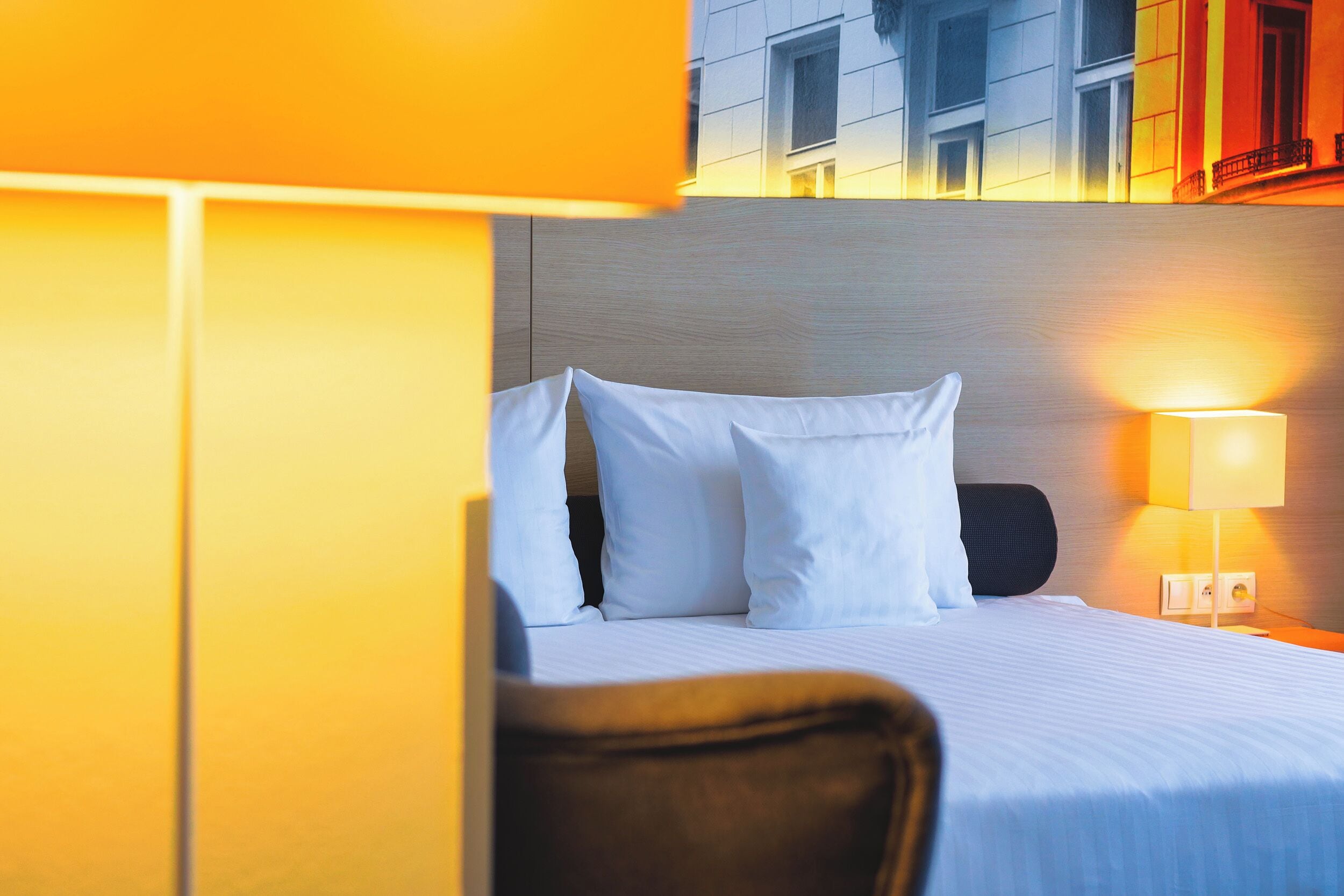 Une chambre d’hôtel avec un lit, une table de chevet et une lampe.
