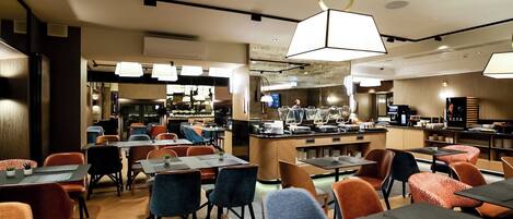 Un restaurant moderne doté d’un bar central, de plusieurs types de sièges, notamment des tables et des banquettes, et d’une cuisine ouverte visible à l’arrière.