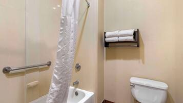 Un baño con bañera, inodoro y perchero para toallas.
