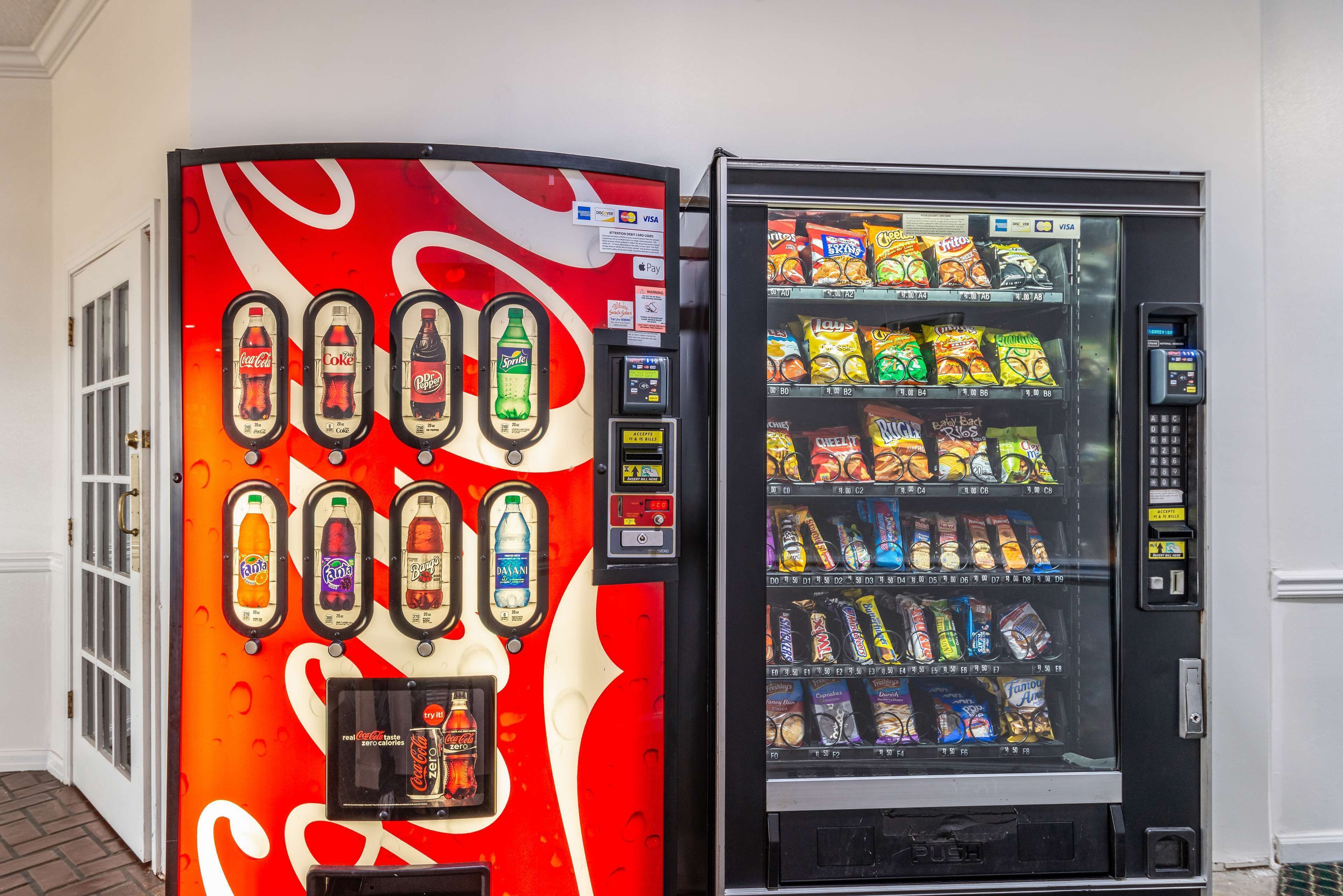 Two vending machines, one with a Coca-Cola design and the other with snacks.
