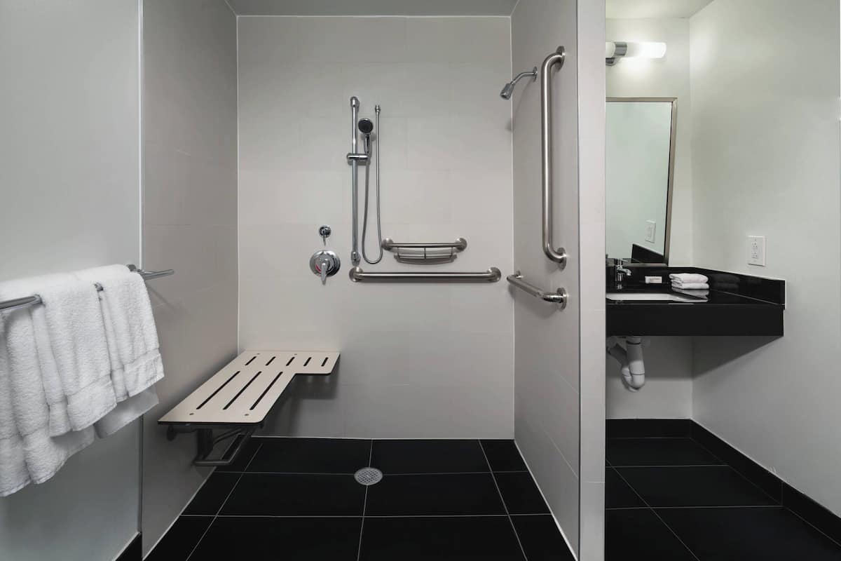 A modern bathroom with a shower, toilet, and sink.