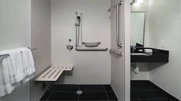 A modern bathroom with a shower, toilet, and sink.