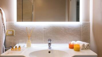 Un bagno con un ampio specchio, un lavandino bianco e un porta asciugamani.