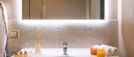 Un baño con un espejo grande, un lavabo blanco y un perchero para toallas.
