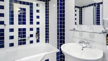 A bathroom with a bathtub, a sink, and a mirror.