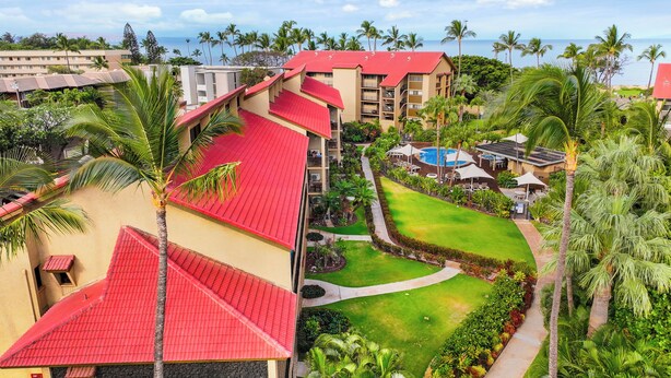 A resort with multiple buildings, a swimming pool, and lush greenery. - Maui Schooner Resort (Kihei)