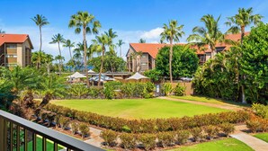 A resort with multiple buildings, palm trees, and a well-maintained lawn. - Maui Schooner Resort (Kihei)