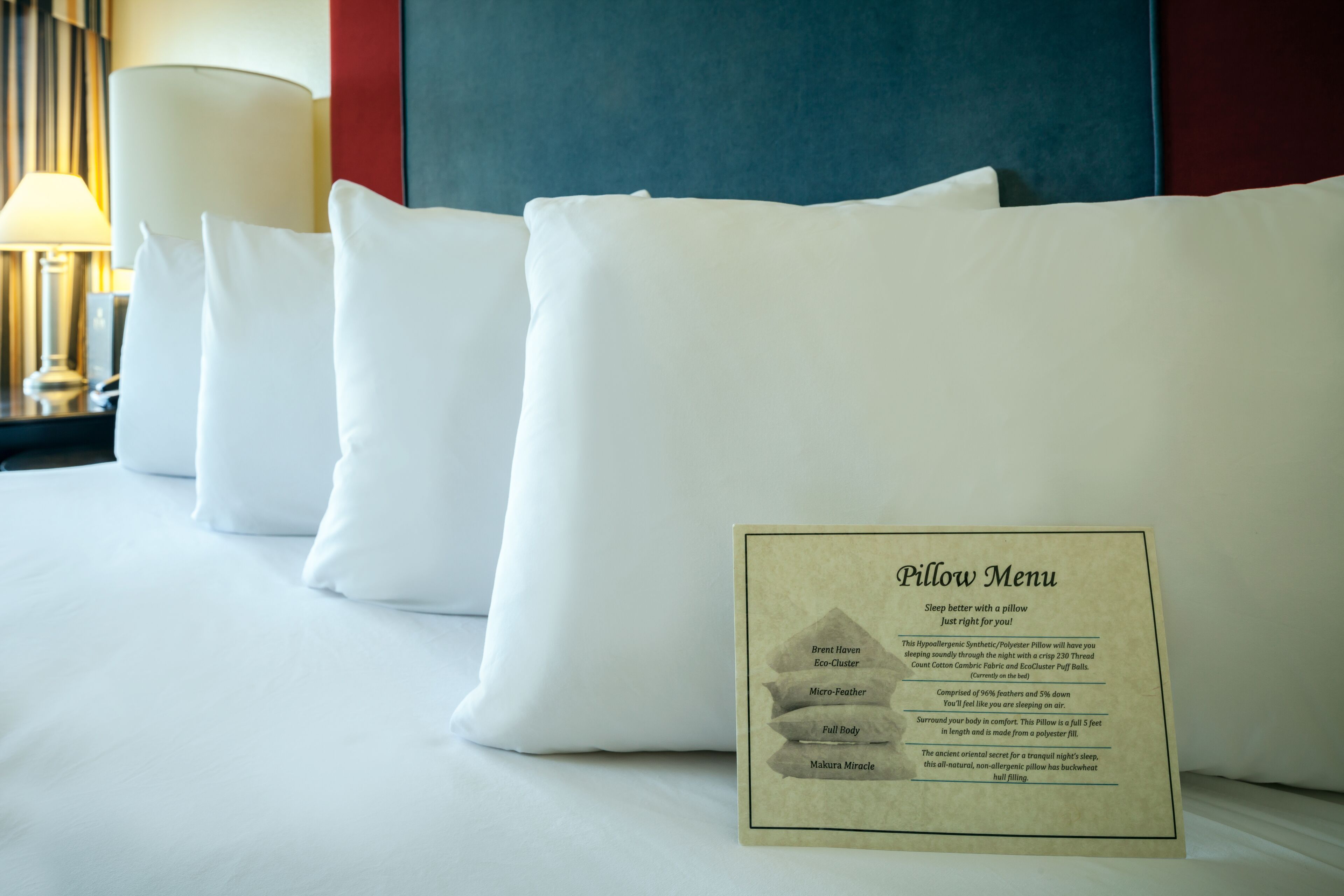 Ein Hotelzimmer mit Bett, Kissen und einer Kissenkarte.