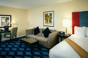 Una habitación de hotel con una cama, un sofá, un escritorio y una silla.